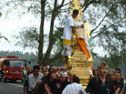 Priest hanging on to a tower in Bali, Indonesia